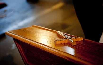 A cross lays on a pew 