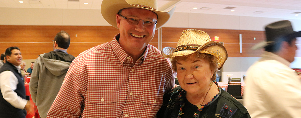 Dr. Evans and Sr. Kathleen Coughlin pose for a photo together dressed in Western attire