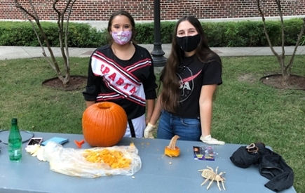 Two students carve pumpkins