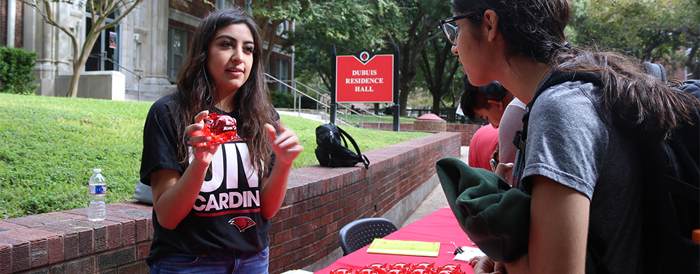 A UIW student holds up a red piggy bank