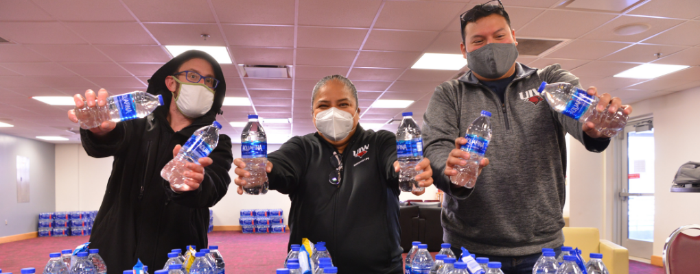 Staff members hold water bottles