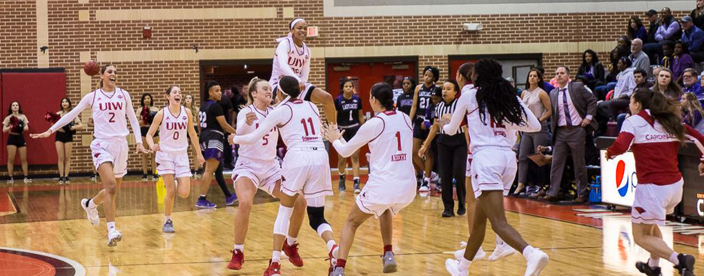 Womens basketball players celebrate on the court