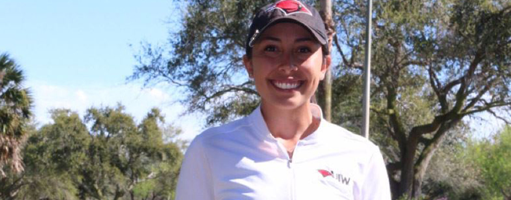A golf player smiles at the camera