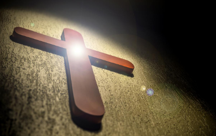 Light shines on a wooden cross