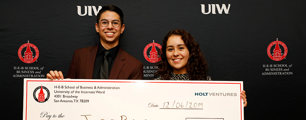 Journey Poles team members hold a large check 