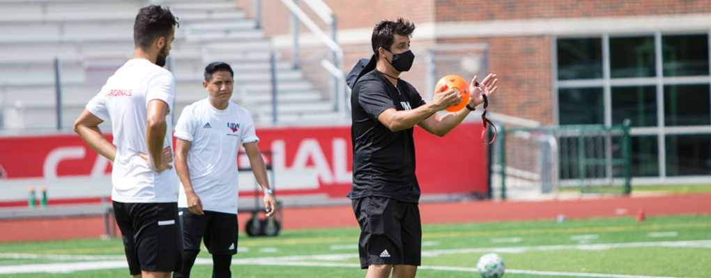 Coach Kiki Lara coaches on the field