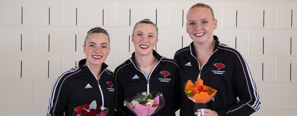 Three synchronized swimmers pose for a photo together