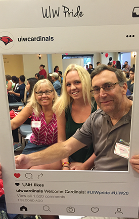 Lauren Rein and her parents pose for a photo with a prop frame