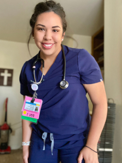 Mikaela poses for a photo in her nursing scrubs
