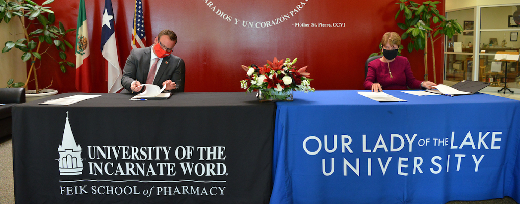 Dr. Evans and Dr. Melby sign documents