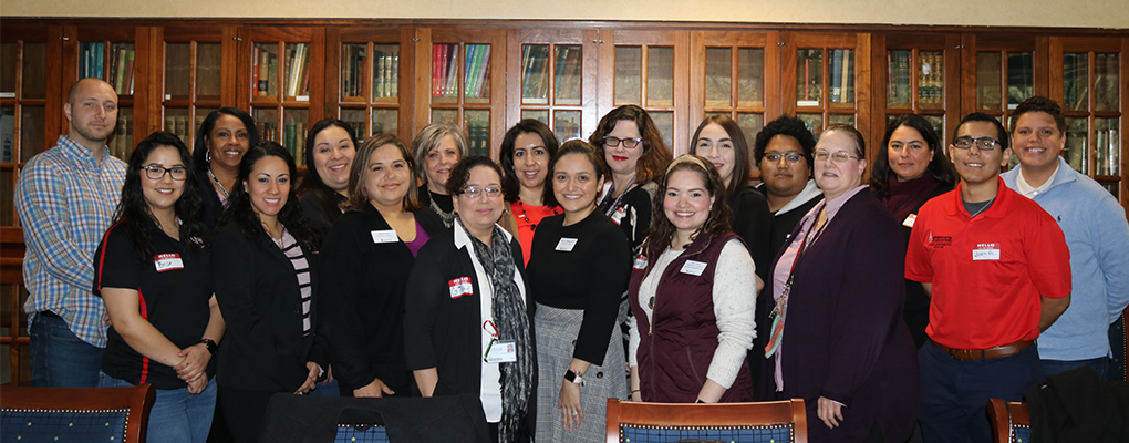 A group of new employees pose for a photo together 