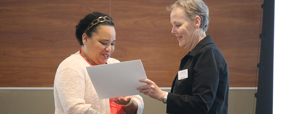 A woman presents a students with a certificate