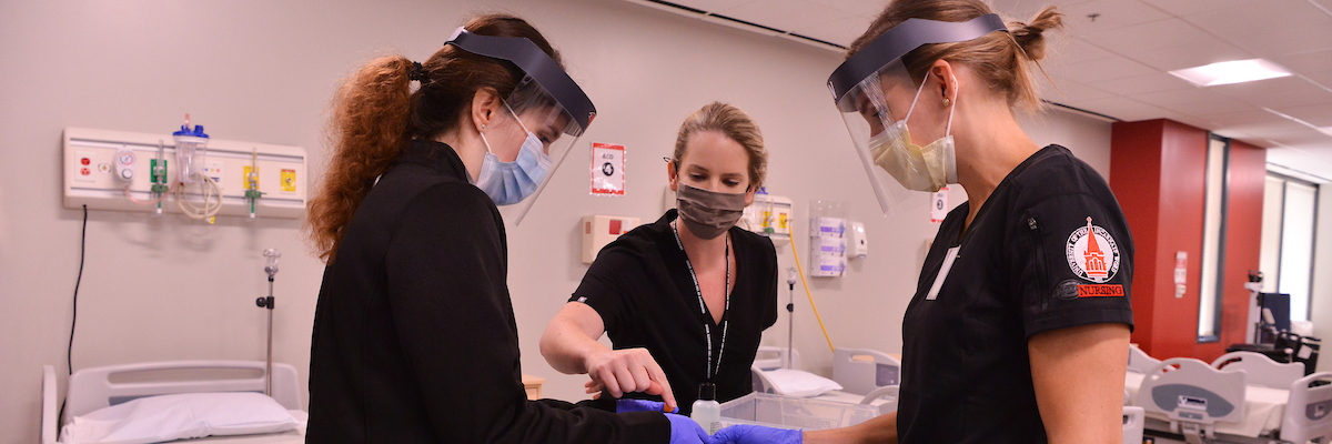 Three nursing students in masks stand together