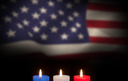 Red, white and blue candles in front of a U.S. flag