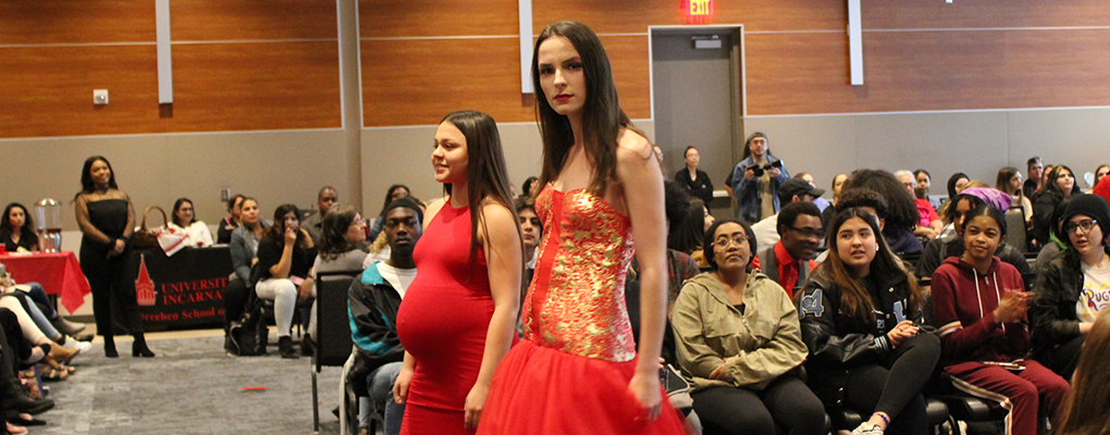 A model poses on the runway next to the dress's designer