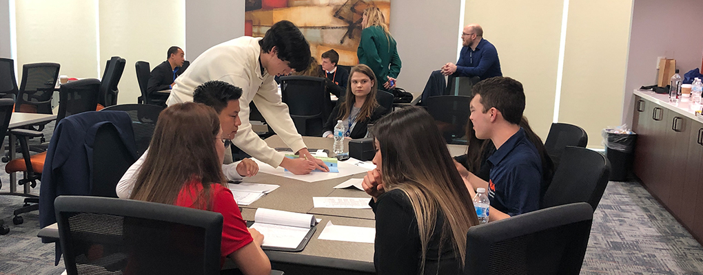 Students huddle around a table