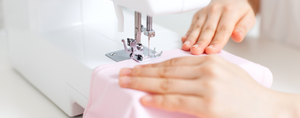A person uses a sewing machine 