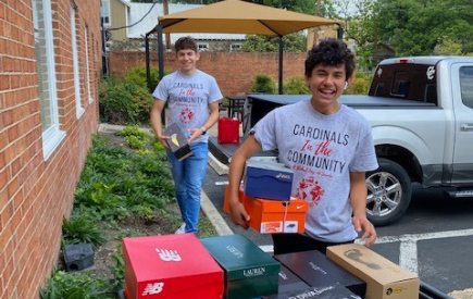 Two students carry shoeboxes