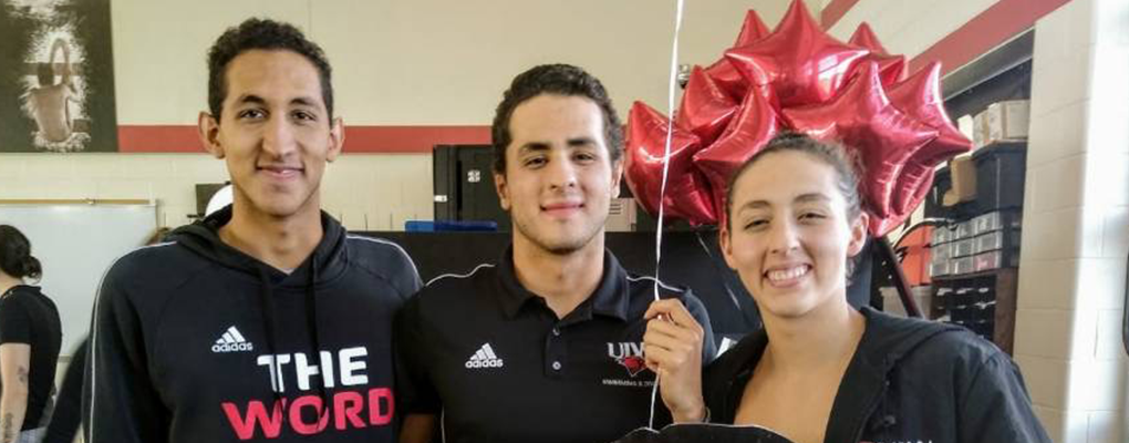 Three siblings pose for a photo together