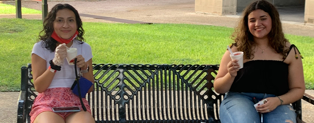 Students enjoy snow cones on a bench