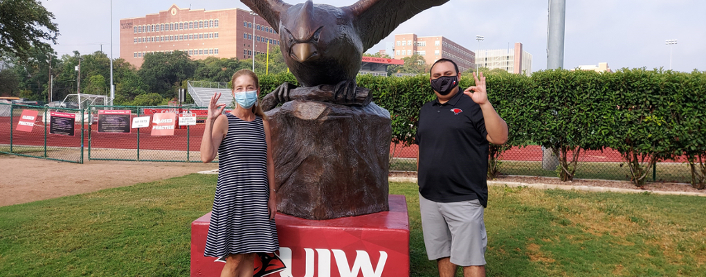 Lisa Townzen and Richard Duran pose making the UIW Cardinal hand sign