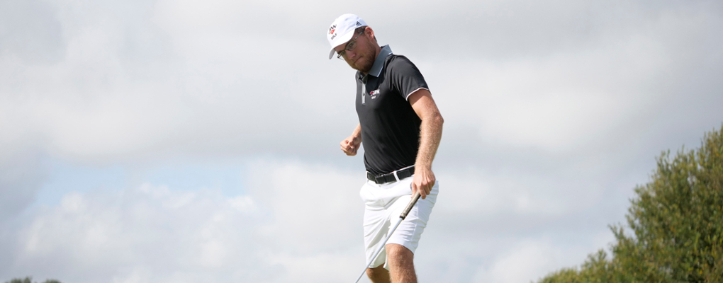 A UIW golfer stands on the golf course