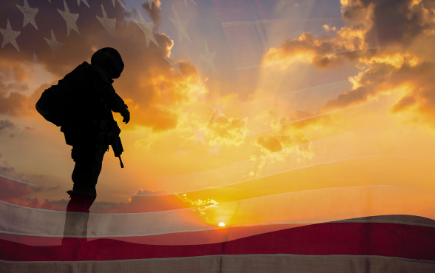 The U.S. flag over an image of a standing soldier