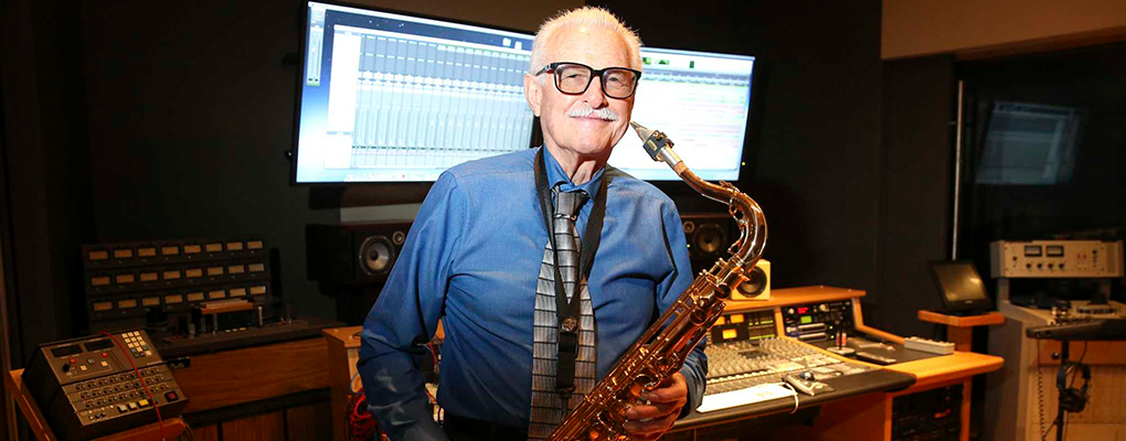 Jim Waller stands with a saxophone 