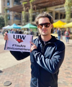 A student holds a sign that says "you are welcome here"