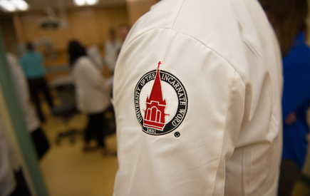 The sleeve of a white coat with the UIW seal