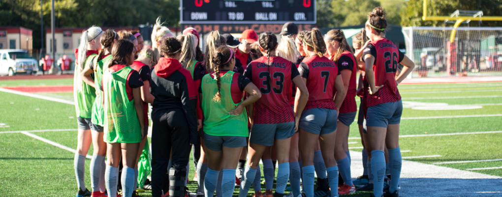 The women's soccer team huddles together