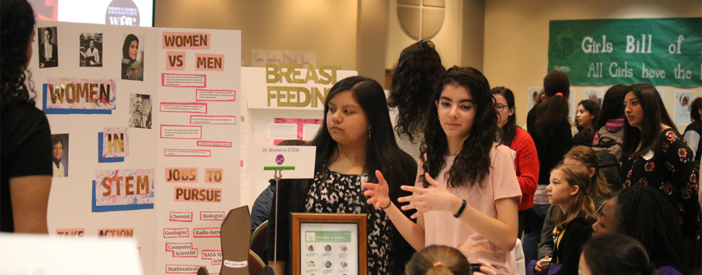 A student delivers a poster presentation