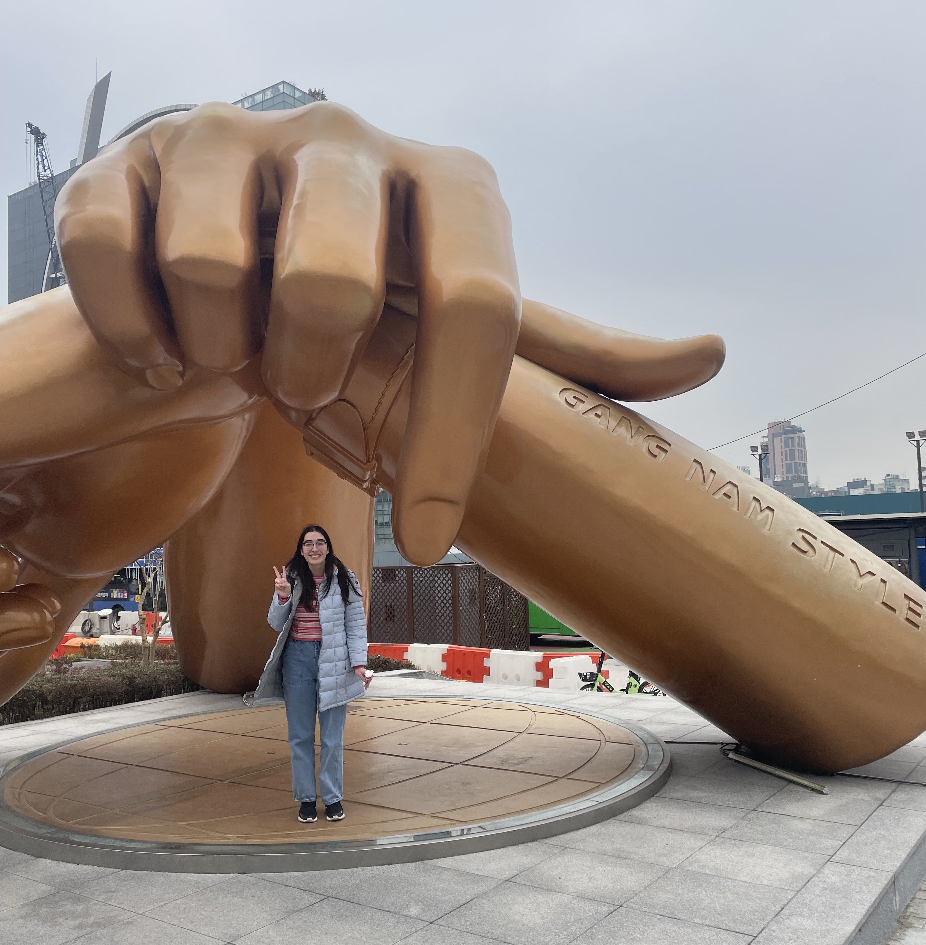 Alexis stands next to a bronze statue in the Gangnam district in Seoul South Korea.